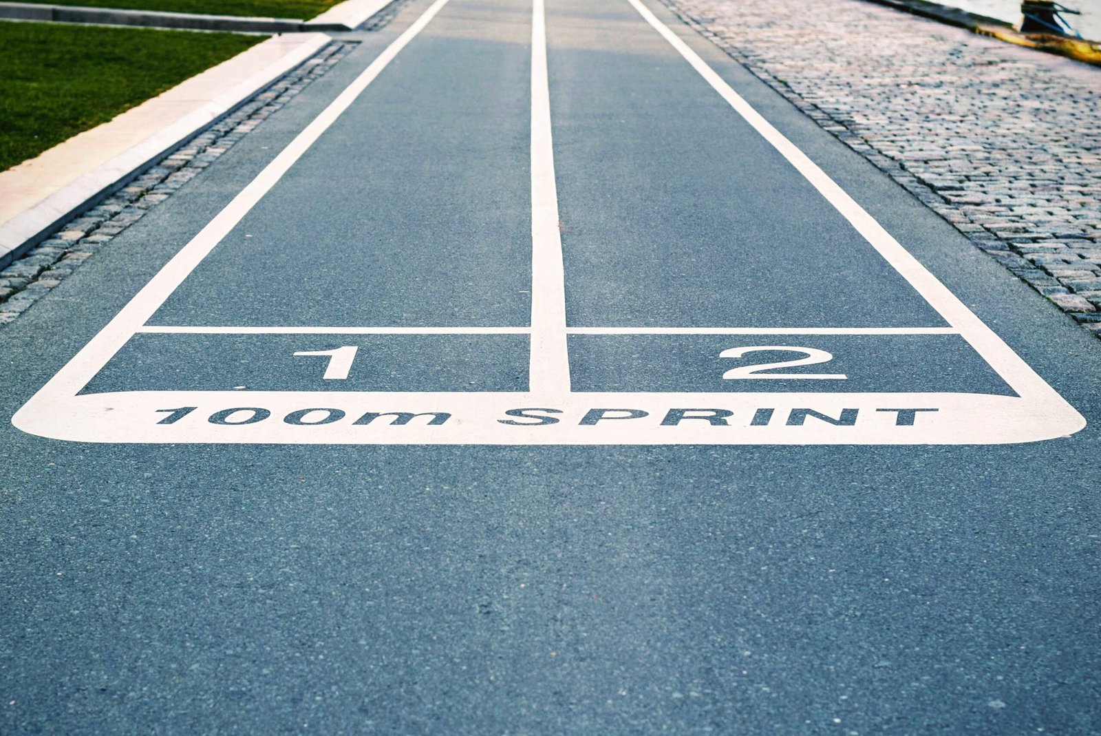 Close-up of outdoor 100m sprint track lanes, perfect for athletics and sprinting events.